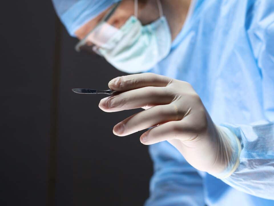 Man surgeon holds a scalpel in an operating room